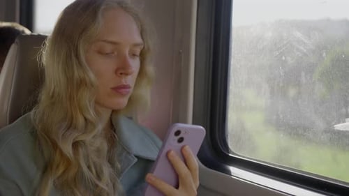 Woman Uses Phone While Riding on Passenger Train