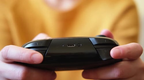 Person Gaming with Black Controller Close Up