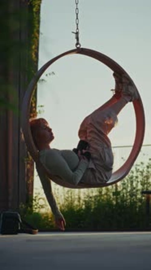 Teen Photographer Taking A Break On A Circular Swing Chair