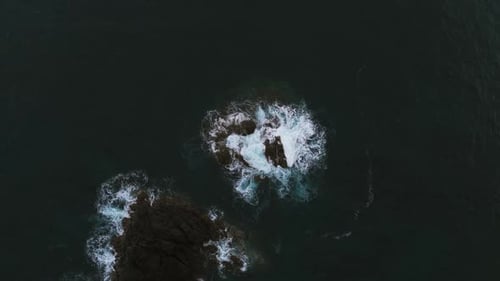 Moody Aerial Top Down View Of Ocean Waves Crashing Over Rocks