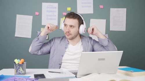 Man with Headphones Studying at Desk