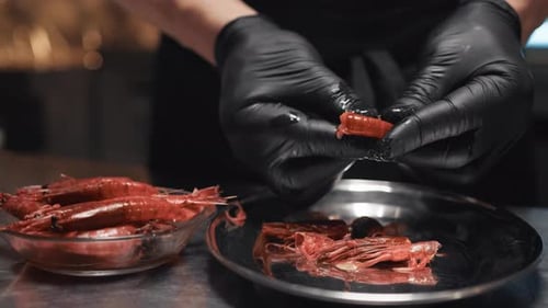 Chef Peeling Shrimp with Gloves in Kitchen