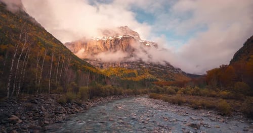 zoom in timelapse Ordesa national park valley mountains and river on a cloudy and misty winter after