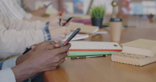 Closeup of Hands Using Smartphones Touching Screen Browsing While Students Learning on Campus