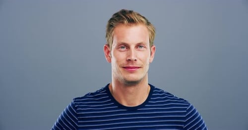 4k-Videomaterial eines jungen Mannes, der vor grauem Hintergrund zwinkert