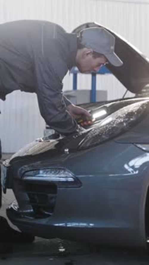 Mécanicien en service automobile réparant le compartiment moteur pour le luxe