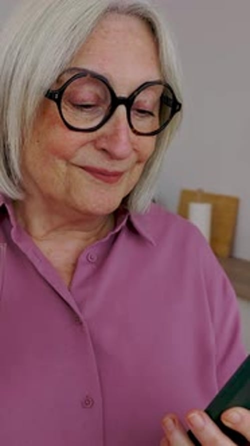 Smiling Mature Woman With Cellphone Drinking Water