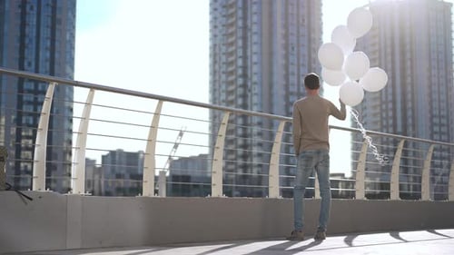 A Young Person Better Enjoying Multiple Colorful Balloons Against a Bright Sunny City View