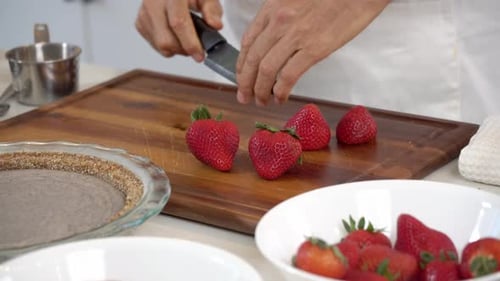 Cutting strawberries adding in bowl to make homemade dairy-free vegan plant based cheesecake diet he