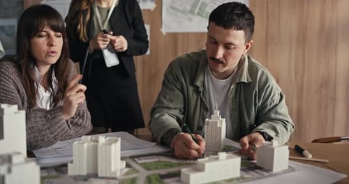 Équipe discutant d'un modèle architectural dans un bureau