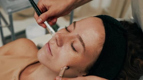 Woman Receiving Facial with Two Brushes Close Up