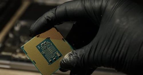 Man with central processing unit of laptop at table, closeup