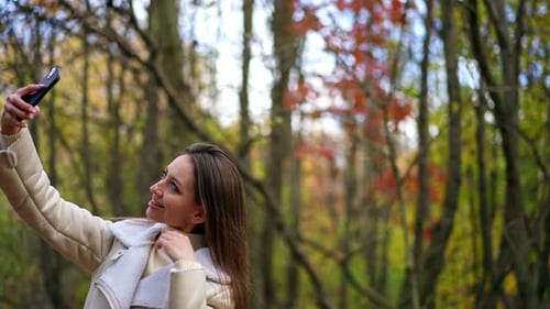 Woman Taking Smartphone Selfie in Autumnal Park