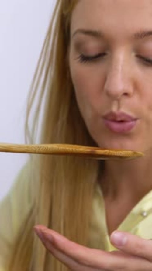 Woman Tastes Sauce From Pot and Smiles