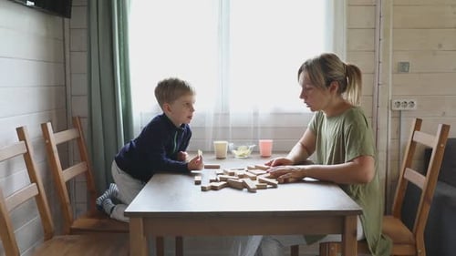 Mutter und Sohn spielen am Nachmittag zu Hause ein Jenga-Spiel