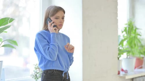 Woman Talking on Phone while Sitting in Window