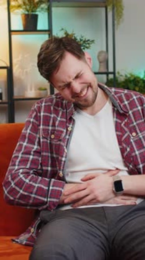 Man Experiencing Abdominal Pain on Couch