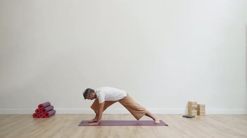 Man practicing stretching forward in modern studio with grounded focus