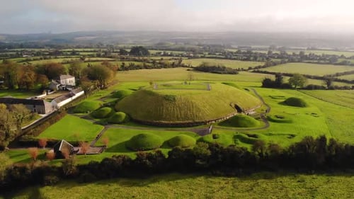 Knowth meghalitic neolitic complex of tombs aerial fly backward shot. World Heritage site located in