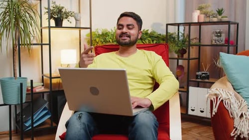 Young Man Video Calling with Laptop at Home