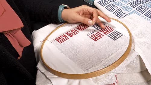 Woman Cross-Stitching on Fabric With Geometric Pattern