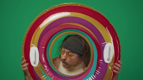 Man Posing With Swim Ring Against Green Background