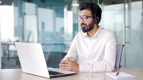 Corporate operator who works in customer support speaks on a video call using a laptop computer.