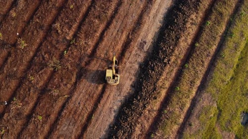 Aerial view of a wheel loader excavator with a backhoe loading sand into a heavy earthmover