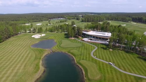 Aerial View of a Lush Golf Course with a Modern Clubhouse and Serene Water Features