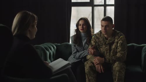 A Member of the Armed Forces of Ukraine Sitting Next to His Wife Holding His Hand Communicates with