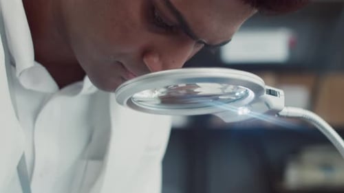 Specialist Using Magnifying Glass during Tablet Repairing