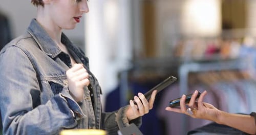 Closeup of customer paying with smartphone at checkout