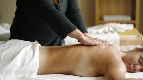 Woman Masseuse Does Oil Massage to a Young Tanned Client Naked Back Closeup Shot Female Spa and