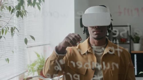 African American Man in VR Headset Interacting with Virtual Elements in Office