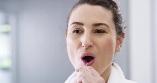 Woman Brushing Teeth in Bathroom Mirror Close Up