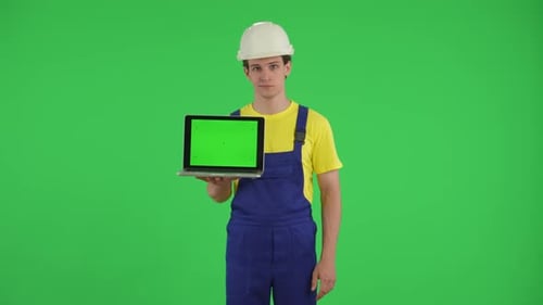 Medium Green Screen Isolated Chroma Key Video of a Young Construction Worker Holding a Laptop with