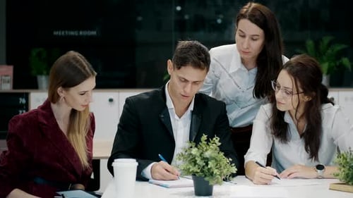 Group of Four Colleagues Gathered Around a Table in an Office Setting Engaged in a Collaborative