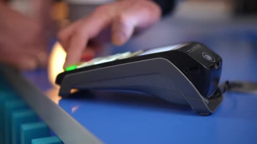 Closeup POS Terminal with Barista Hand Pressing Buttons and Client Paying with Credit Card Leaving