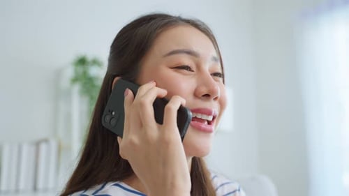 Woman Talking on Smartphone at Home, Smiling