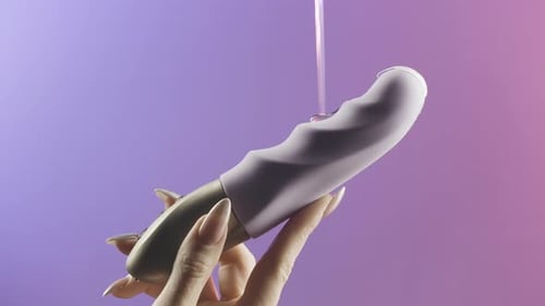 Nahaufnahme einer Frau, die weibliches Sexspielzeug in der Hand hlt Nahaufnahme einer Frau, die weibliches Sexspielzeug in der Hand hlt