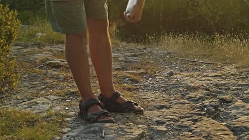 Man Applying Mosquito Repellent on Mountain at Dusk