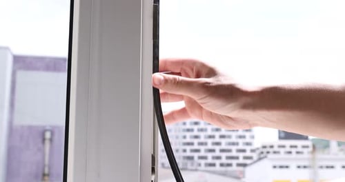 Trabalhador manual instalando uma junta de borracha na janela interna, de perto