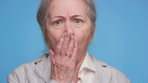 Surprised Senior Woman Reacts with Hand to Mouth