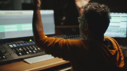Produtor musical gerenciando a mixagem de som durante a sessão de gravação no estúdio de áudio