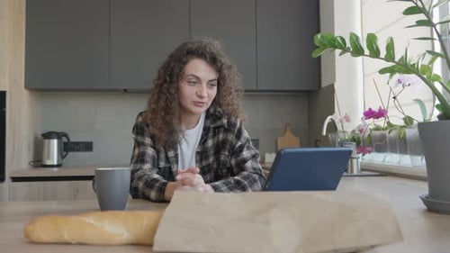 Woman Video Calling on Tablet in Modern Kitchen
