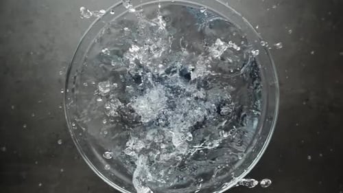 Blueberries Splashing into Water in Clear Glass Bowl