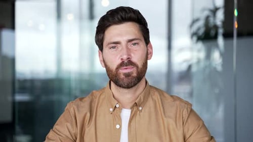 Webcam view. Confident businessman talking on a video call looking at camera sitting at workplace