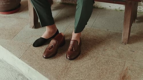Man Tries on Brown Leather Loafers with Tassels