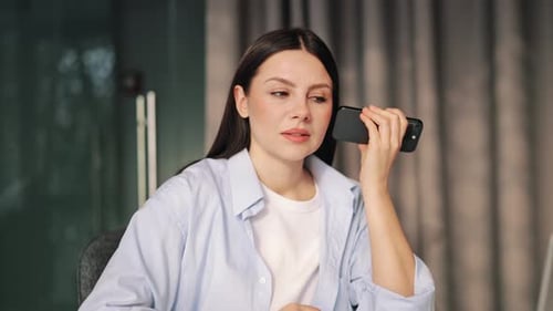 Woman Using Voice Assistant on Phone in Office