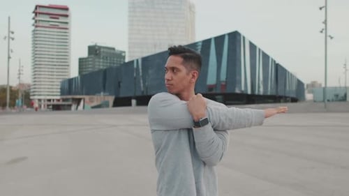 Young Adult Man Stretching Before Exercise in City